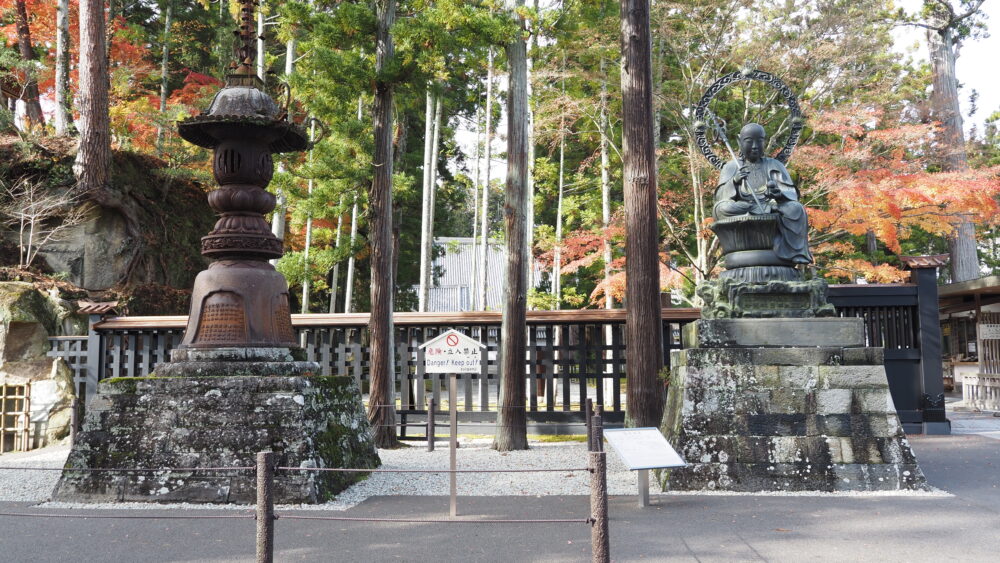 Two statues with foliage background